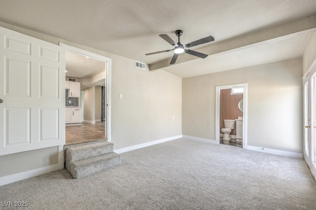 carpeted spare room with a textured ceiling and ceiling fan