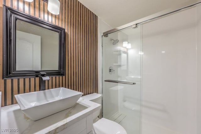 bathroom featuring sink, walk in shower, and toilet