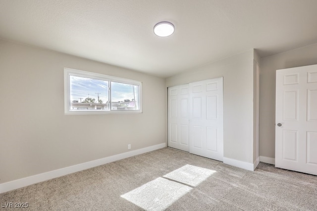 unfurnished bedroom featuring a closet and light carpet