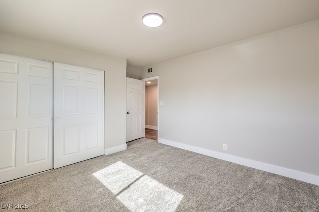 unfurnished bedroom featuring a closet and light carpet