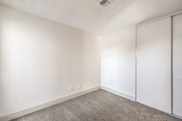 empty room featuring a textured ceiling and carpet floors