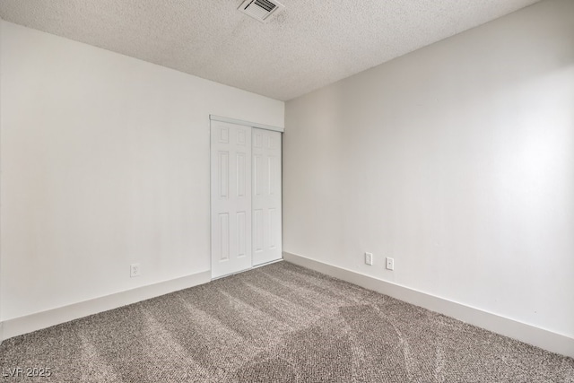 unfurnished bedroom featuring a closet, carpet floors, and a textured ceiling