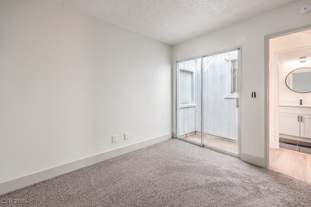 unfurnished bedroom with a textured ceiling, light colored carpet, a closet, and sink