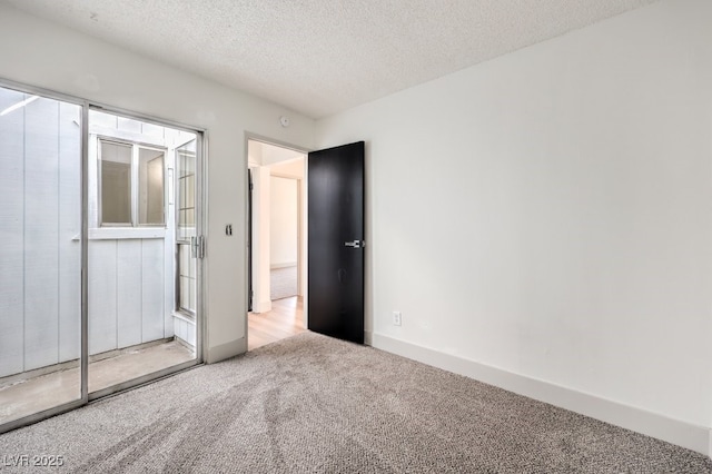 unfurnished bedroom with a textured ceiling and light carpet