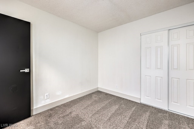 unfurnished bedroom featuring a textured ceiling, a closet, and carpet floors