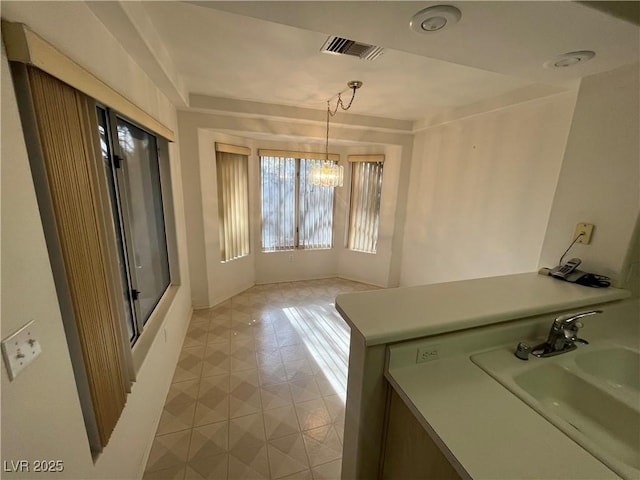 unfurnished dining area featuring a chandelier and sink