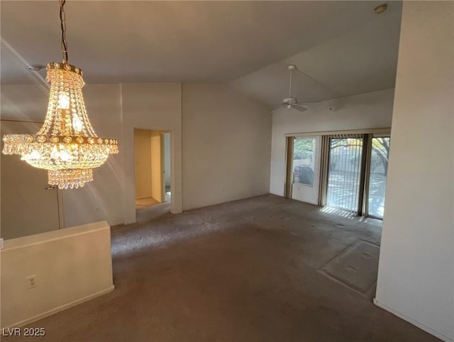 empty room with vaulted ceiling, ceiling fan with notable chandelier, and dark colored carpet