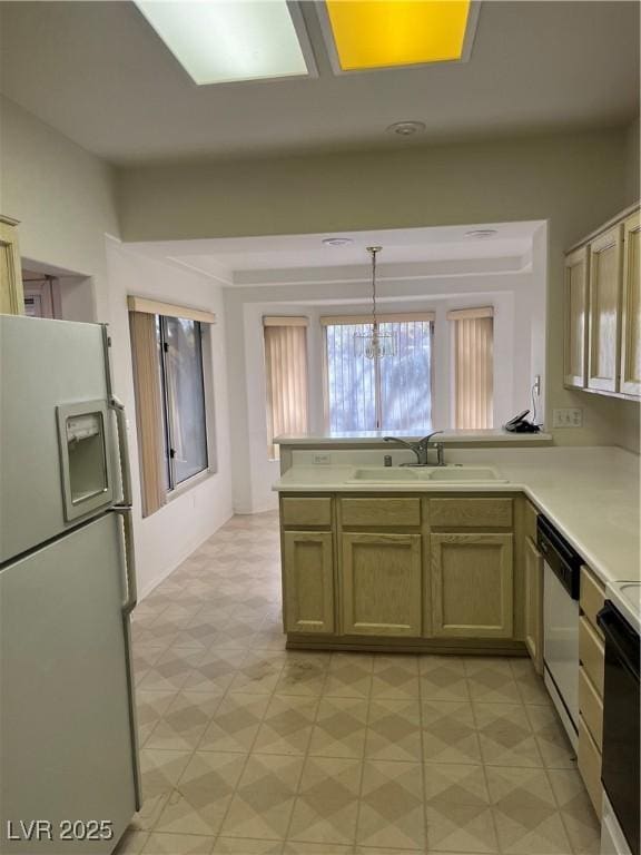 kitchen with kitchen peninsula, white fridge with ice dispenser, hanging light fixtures, and sink