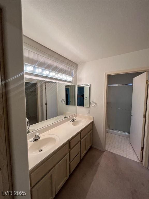 bathroom featuring a shower with door and vanity