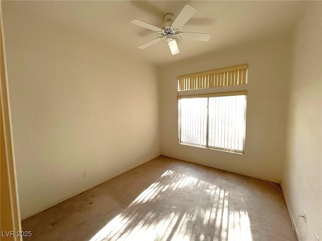 carpeted spare room with ceiling fan