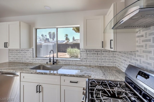 kitchen featuring white cabinetry, appliances with stainless steel finishes, wall chimney exhaust hood, and sink