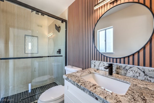 bathroom featuring walk in shower, vanity, and toilet