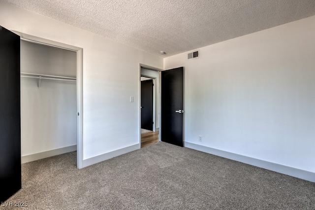 unfurnished bedroom featuring a textured ceiling, a closet, and carpet floors