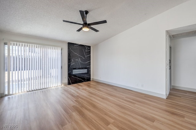 unfurnished living room featuring a textured ceiling, ceiling fan, and light wood-type flooring