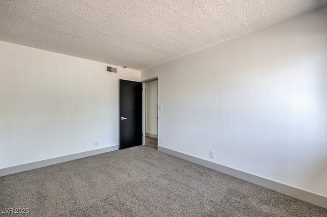 spare room with a textured ceiling and carpet floors