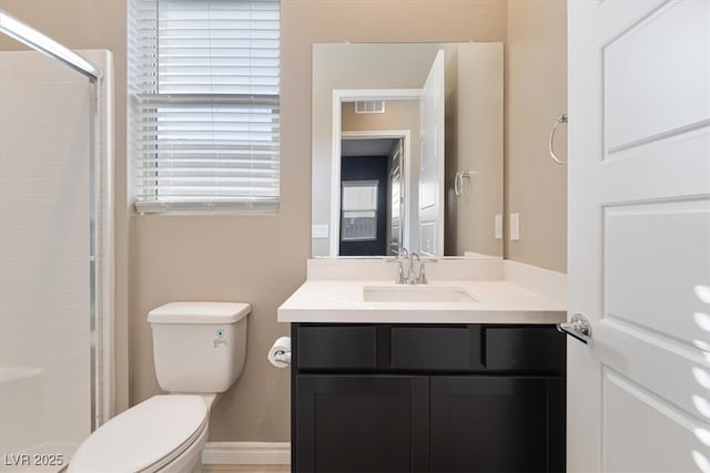 bathroom featuring vanity, an enclosed shower, a wealth of natural light, and toilet