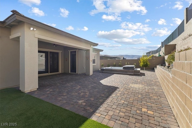 view of patio / terrace with a hot tub and ceiling fan