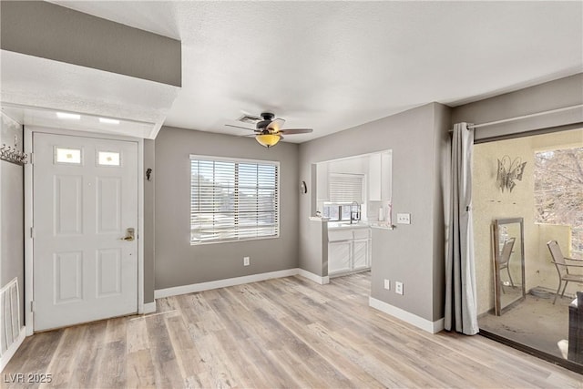 entryway with ceiling fan and light hardwood / wood-style floors