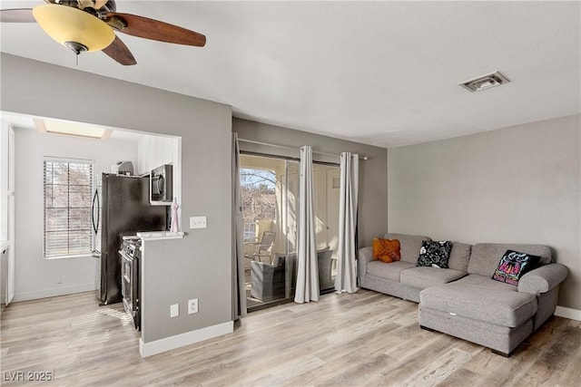 living room featuring ceiling fan and light hardwood / wood-style floors