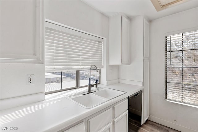 kitchen with sink, white cabinets, light wood-type flooring, and dishwasher