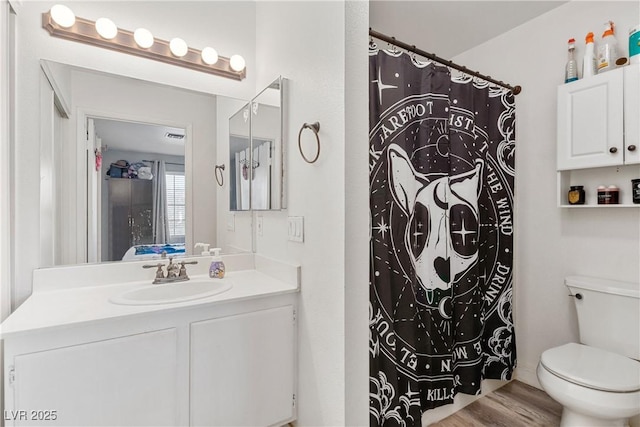 bathroom featuring toilet, a shower with shower curtain, vanity, and hardwood / wood-style flooring