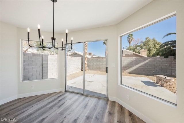 dining area with hardwood / wood-style flooring and an inviting chandelier