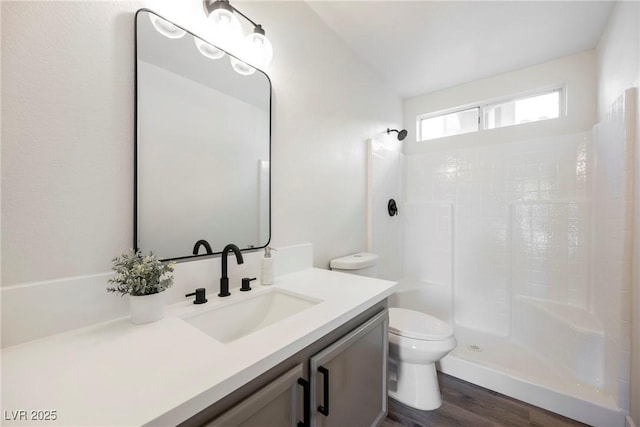 bathroom with walk in shower, vanity, hardwood / wood-style flooring, and toilet