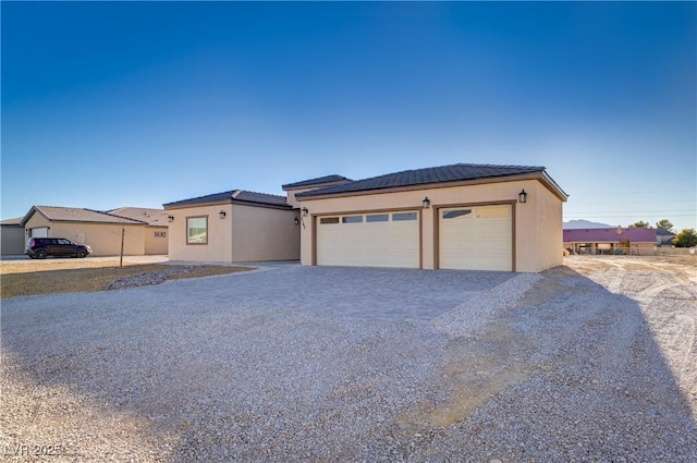 2140 Upland Ave, Pahrump, NV 89048 - view of front of home with stucco siding, driveway, a tiled roof, and a garage