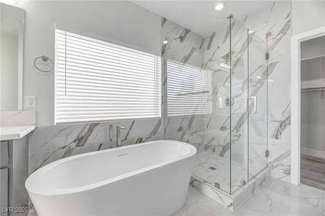 full bath with a marble finish shower, a soaking tub, marble finish floor, vanity, and recessed lighting