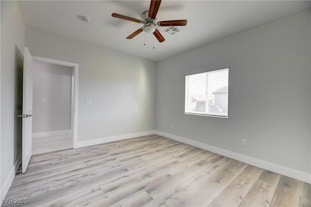 spare room with light wood-style floors, baseboards, and a ceiling fan