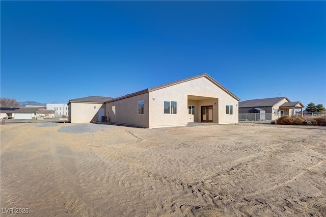 view of front of property with fence and stucco siding