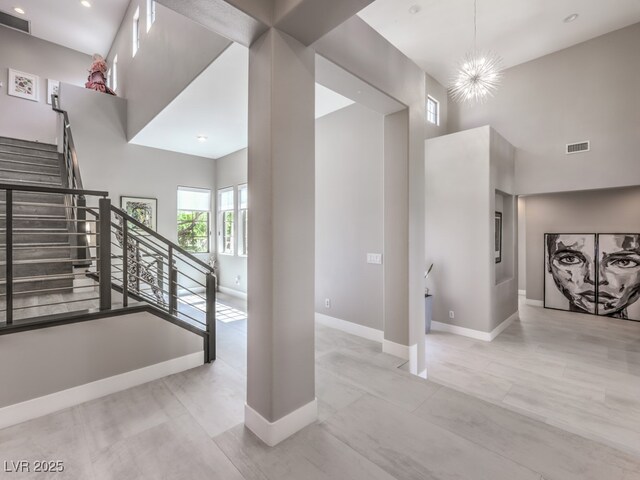 stairway with a high ceiling and a chandelier