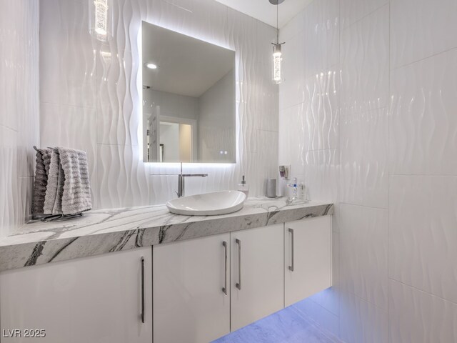 bathroom featuring tile walls and vanity