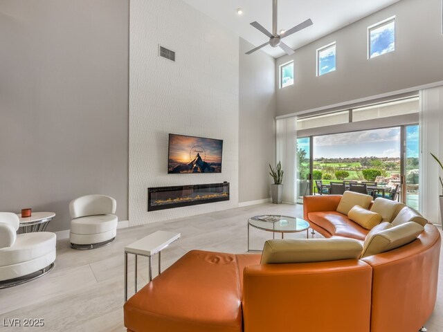 living room featuring ceiling fan and a high ceiling