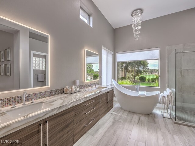 bathroom featuring hardwood / wood-style flooring, vanity, a chandelier, and shower with separate bathtub