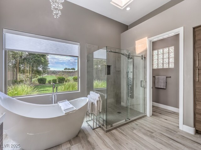 bathroom featuring wood-type flooring and shower with separate bathtub