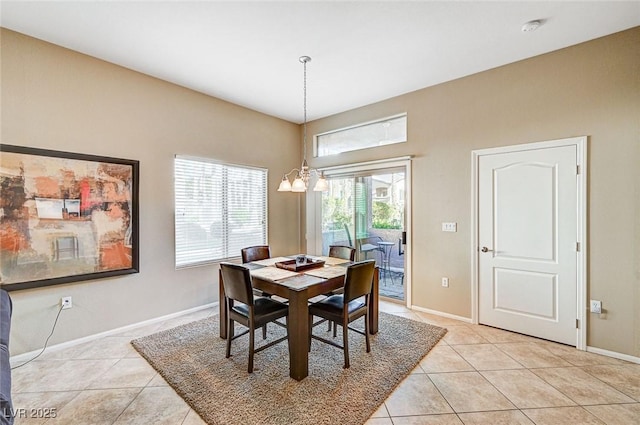 tiled dining room featuring an inviting chandelier