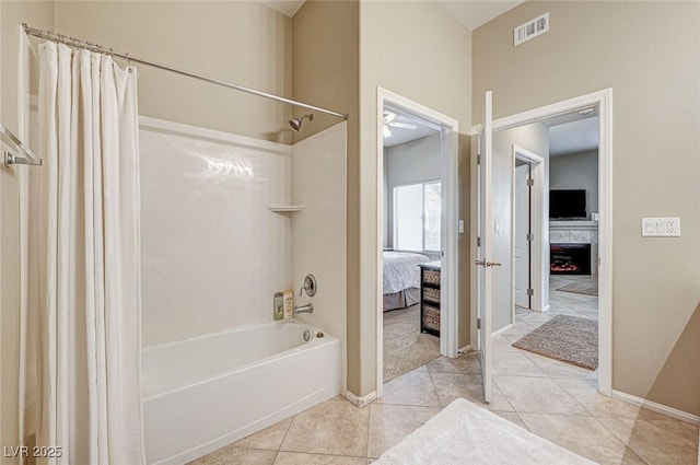 bathroom with shower / bath combo with shower curtain, tile patterned floors, and a fireplace