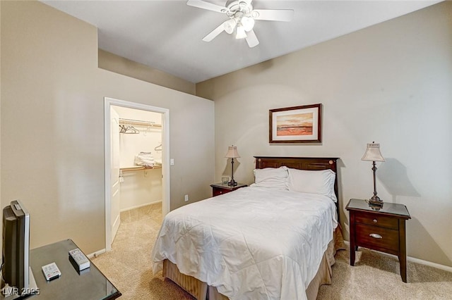 carpeted bedroom with ceiling fan, a spacious closet, and a closet