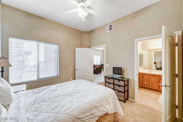 bedroom featuring ensuite bathroom, ceiling fan, light tile patterned floors, and sink