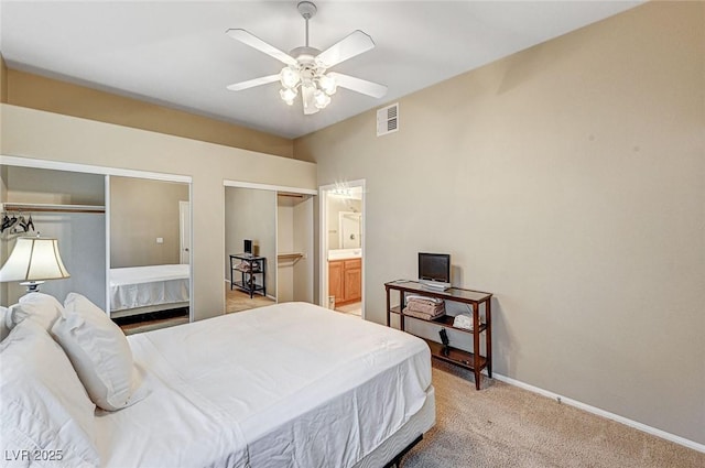 carpeted bedroom with ensuite bathroom and ceiling fan