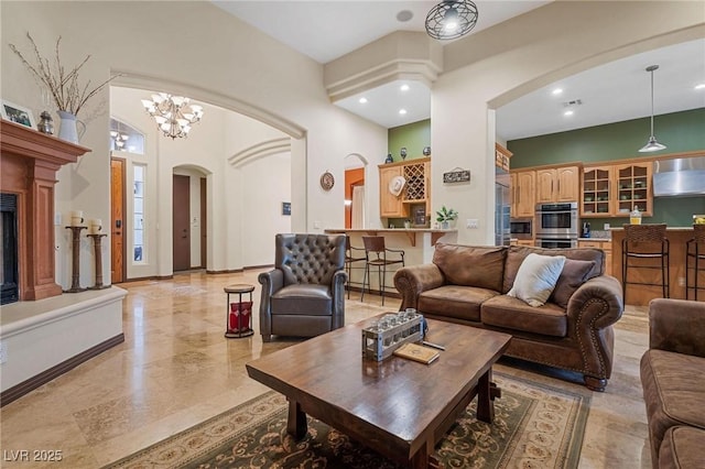 living room featuring a towering ceiling and a notable chandelier