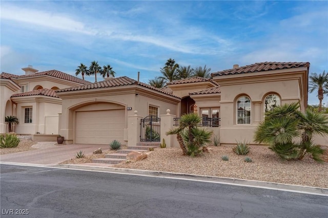 mediterranean / spanish house featuring stucco siding, a tiled roof, concrete driveway, and a garage