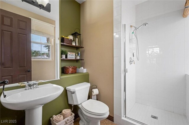 bathroom with a shower with shower door and toilet