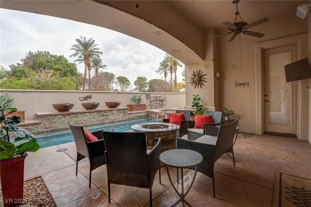 view of patio with a fire pit and ceiling fan