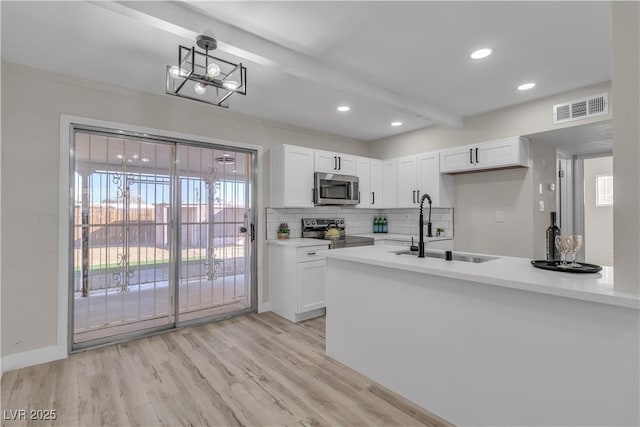 kitchen featuring white cabinets, stainless steel appliances, light hardwood / wood-style floors, and sink