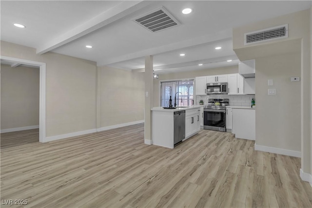 kitchen featuring stainless steel appliances, light hardwood / wood-style floors, white cabinets, beamed ceiling, and sink