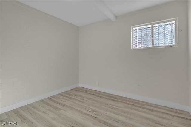 spare room with beam ceiling and light hardwood / wood-style floors