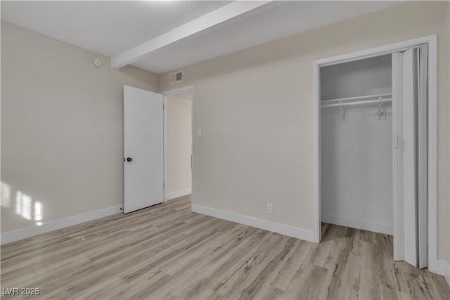 unfurnished bedroom featuring a closet and light hardwood / wood-style flooring