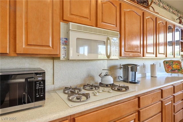 kitchen featuring white appliances and tasteful backsplash